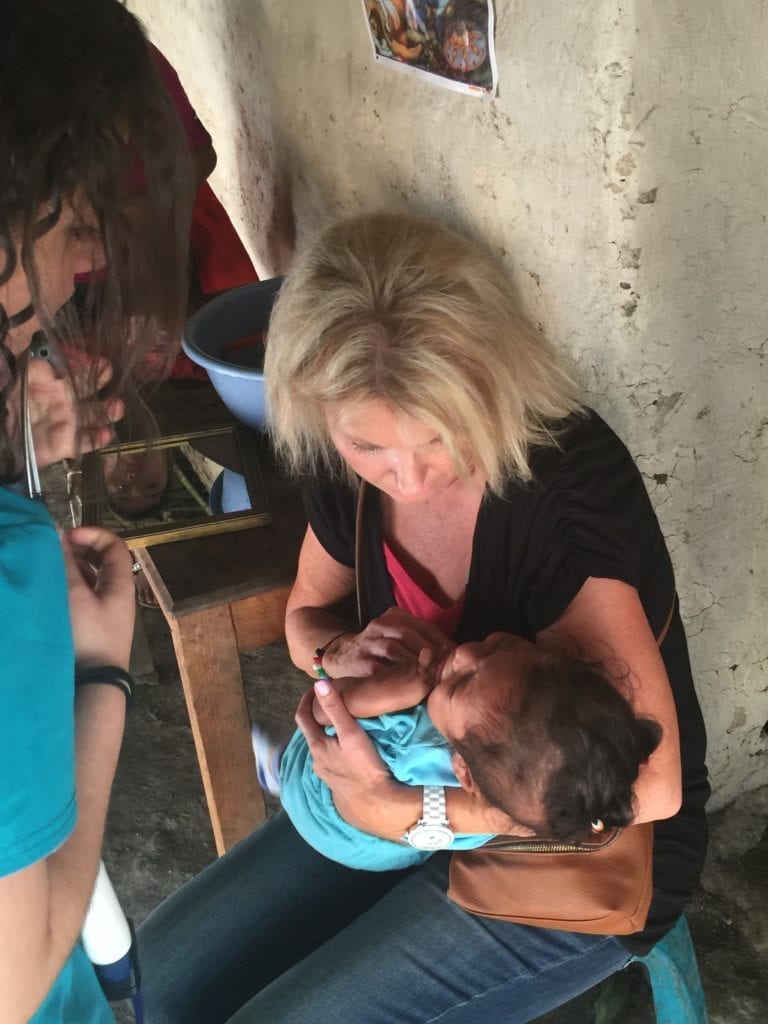 Holly comforting and holding toddler girl in Guatemala